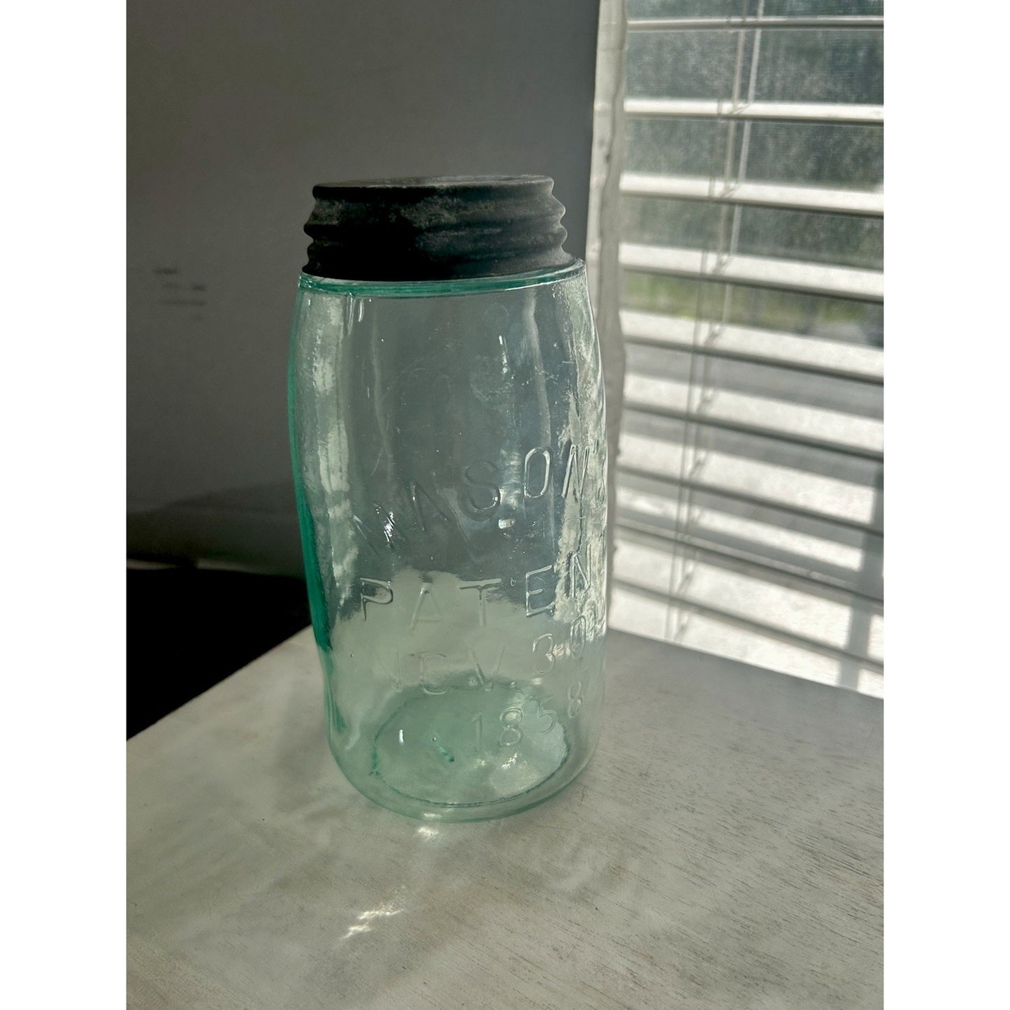 Antique Mason's Patent Nov. 30th 1858 quart jar — aqua glass with zinc lid and visible seed bubbles, front view