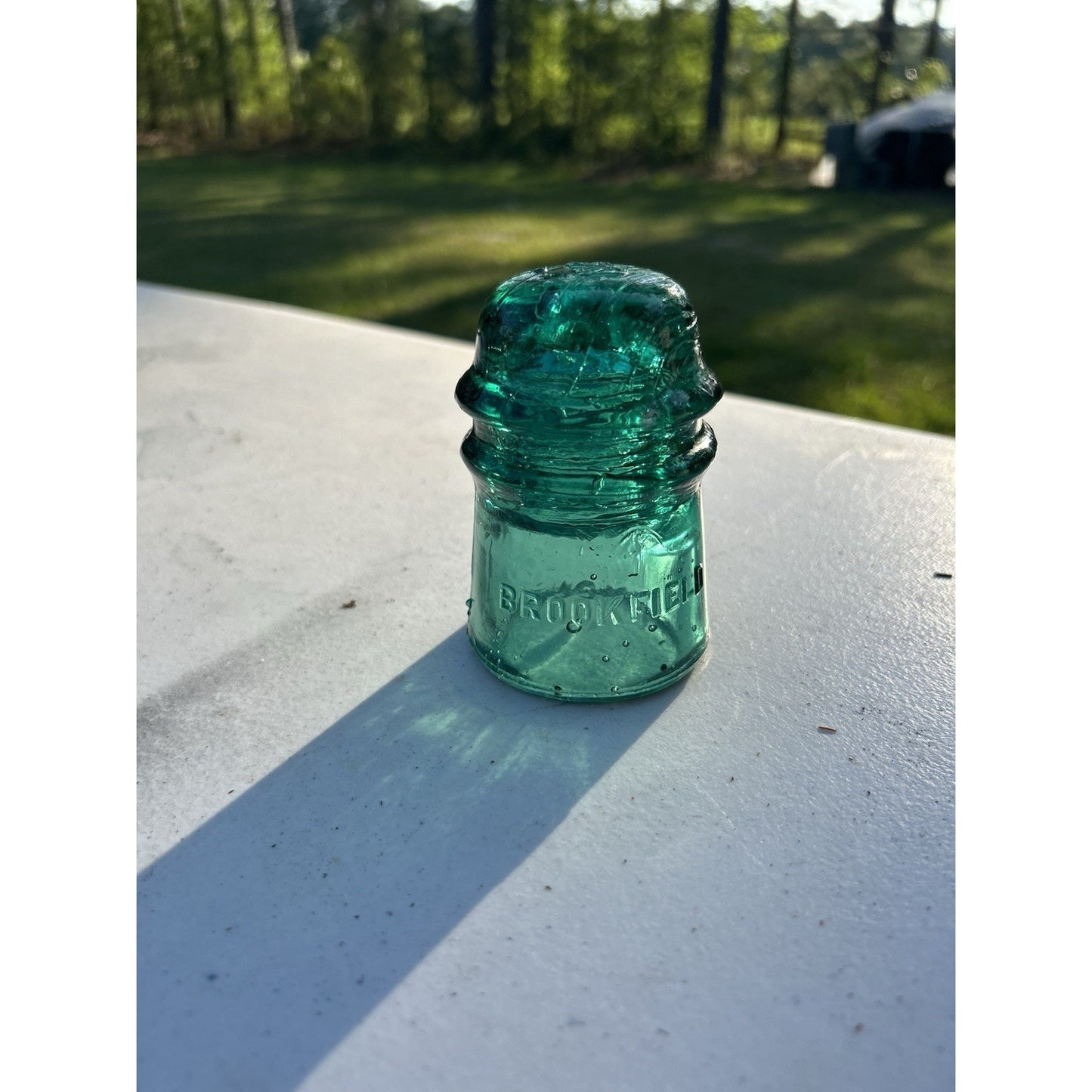 Dark emerald green Brookfield glass insulator crown top detail