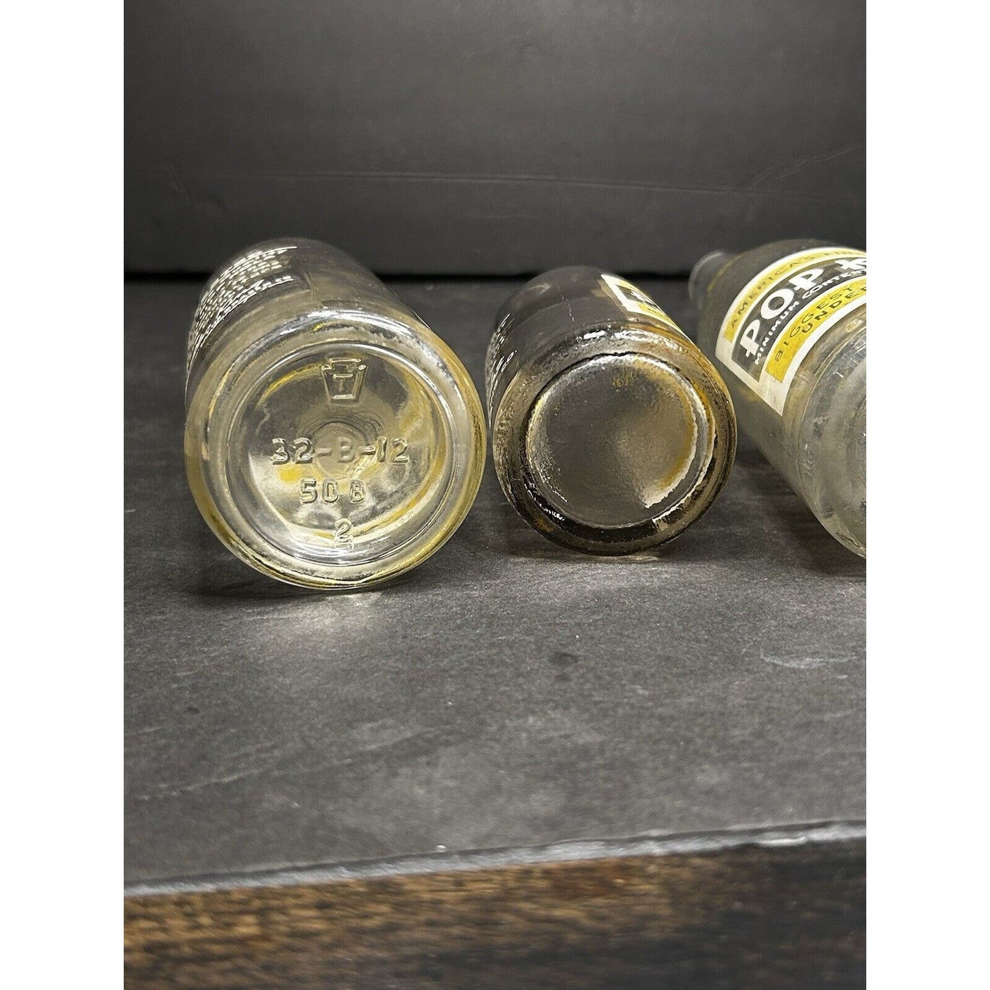 Vintage Pop Kola advertising bottles natural light — clear glass with yellow label, 1930s soda collectible