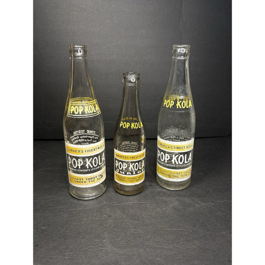Set of 3 antique Pop Kola Junior soda bottles — 1930s-era ACL applied color label glass, embossed yellow and white