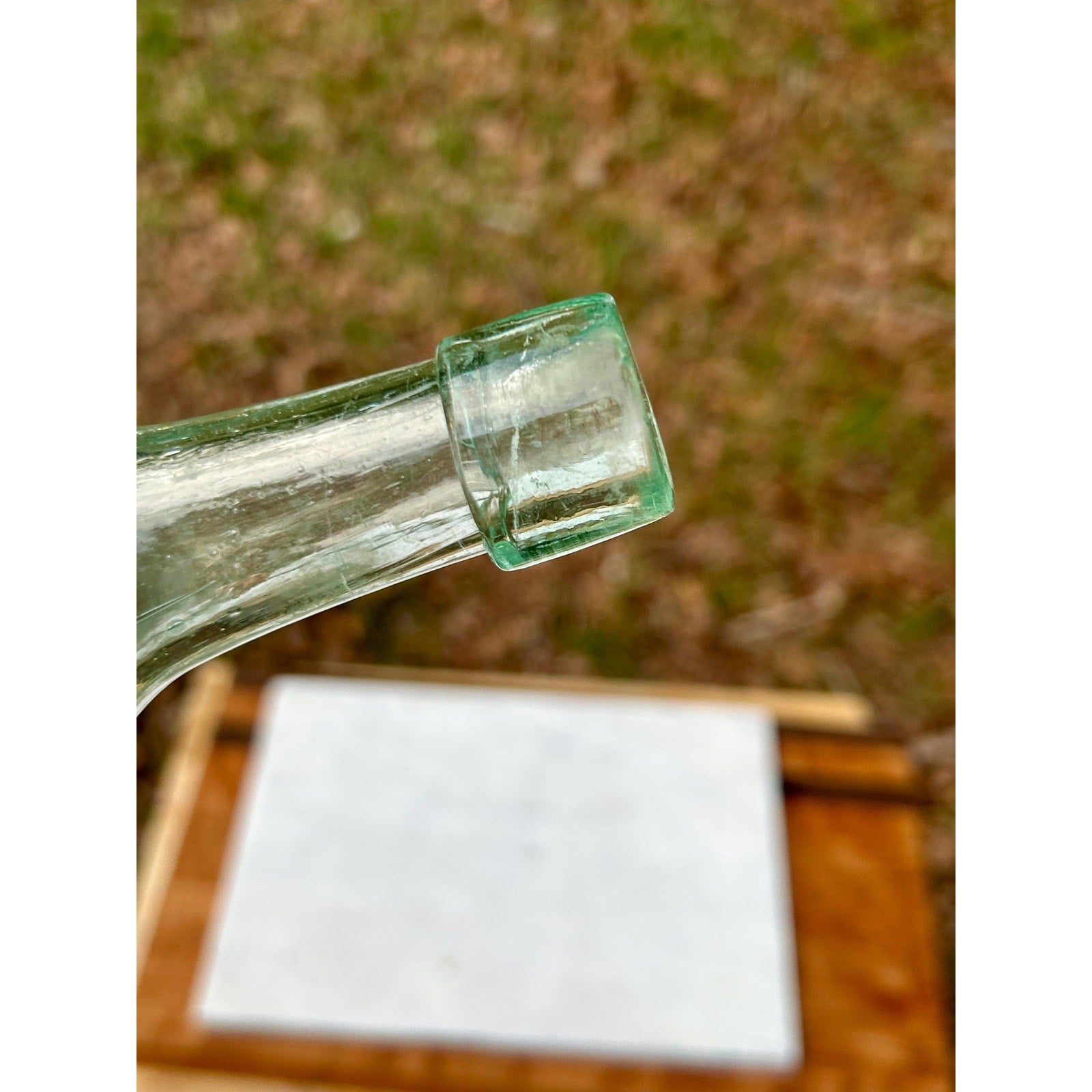 Antique hand-blown aqua bottle showing whittle marks and glass character
