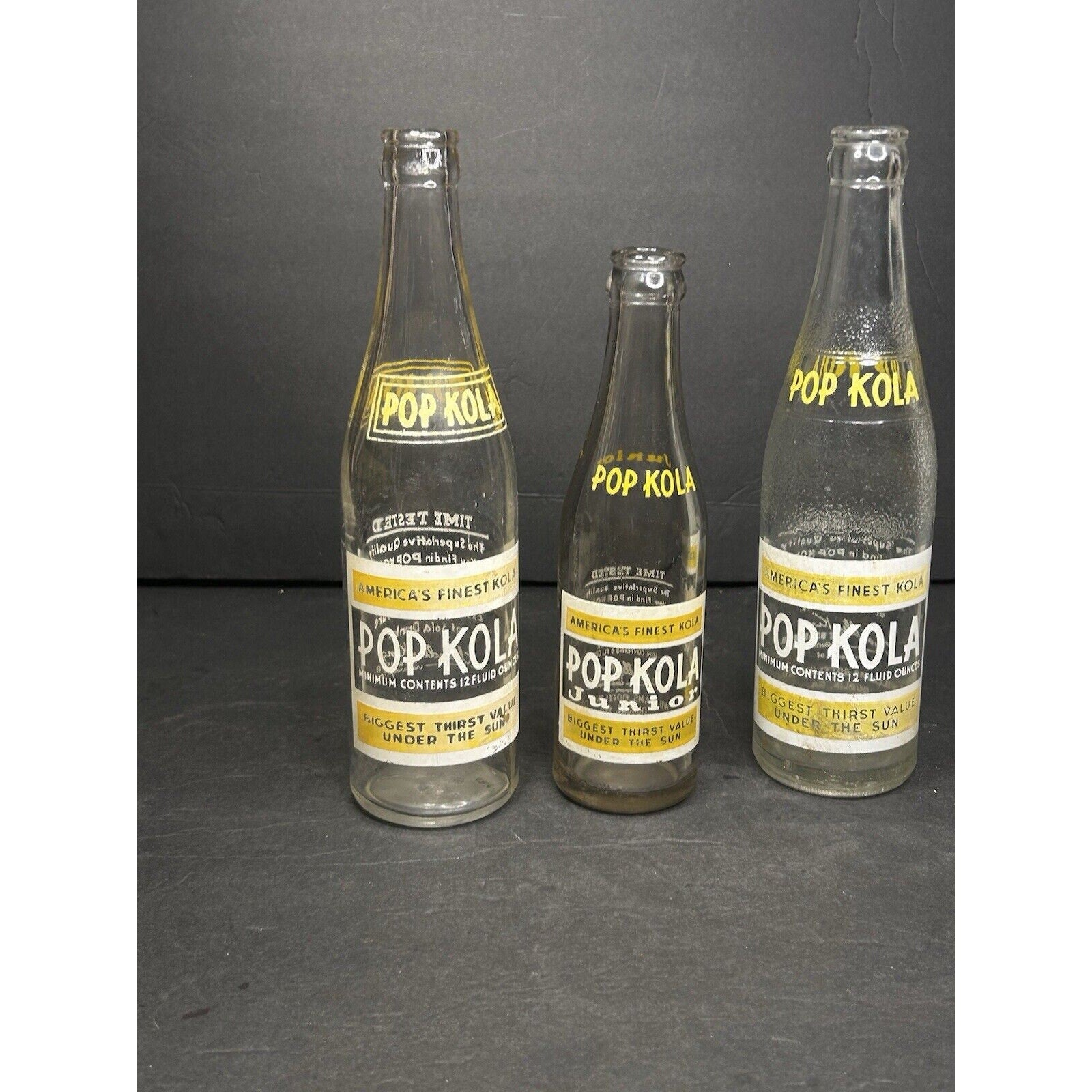 Pop Kola soda bottles 1930s set side view — original ACL label printing on clear glass, cola advertising collectible