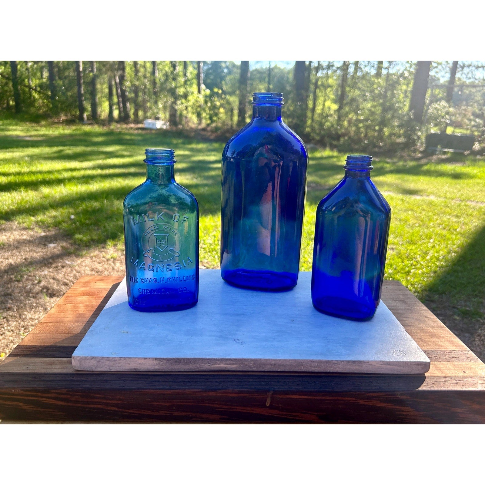 Antique cobalt blue apothecary bottle detail — embossed glass pharmaceutical bottle — deep sapphire color