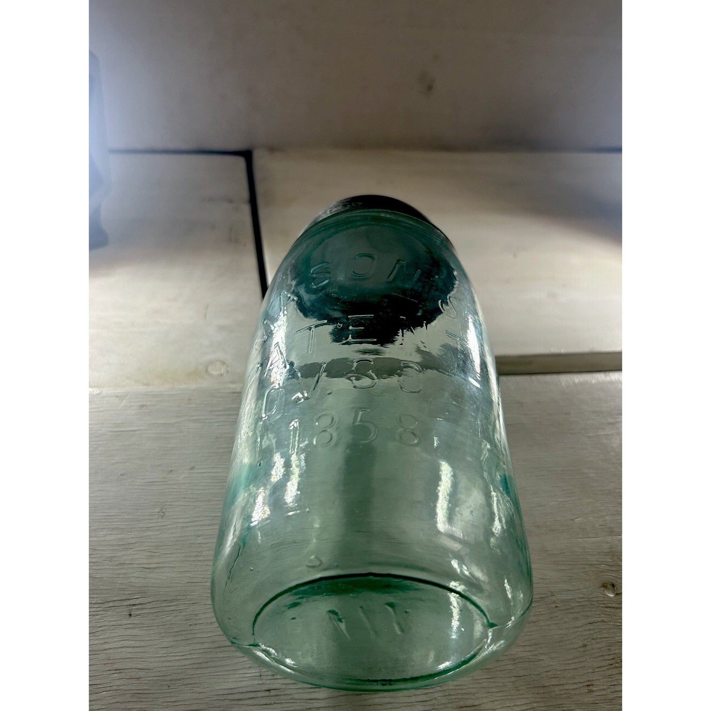 Mason's Patent 1858 quart jar backlit — aqua glass color and seed bubble distribution visible