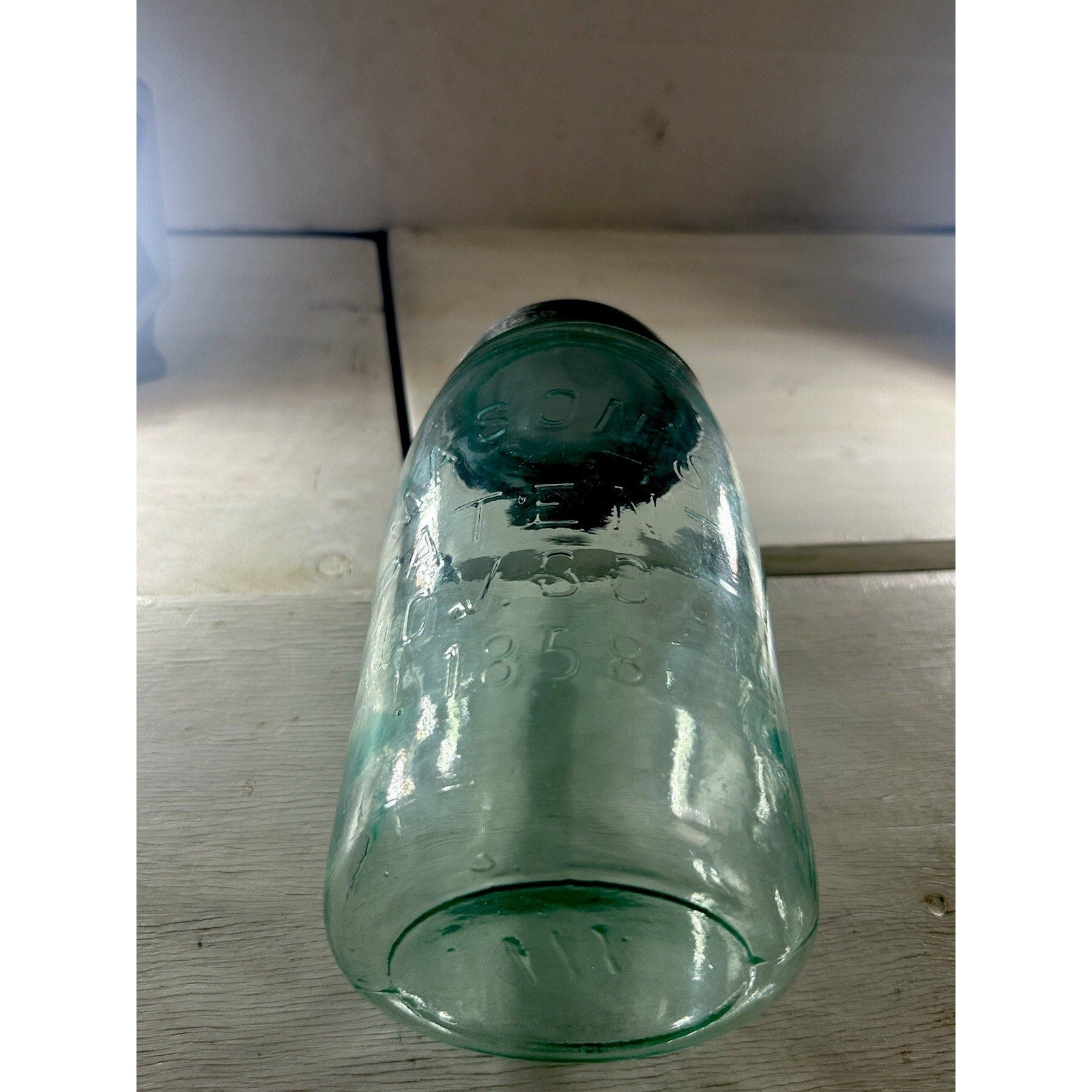 Mason's Patent 1858 quart jar backlit — aqua glass color and seed bubble distribution visible