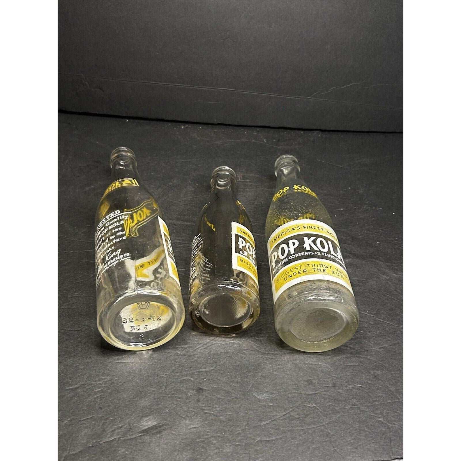 Rare vintage Pop Kola soda bottle set full profile — matched trio of antique ACL advertising glass bottles
