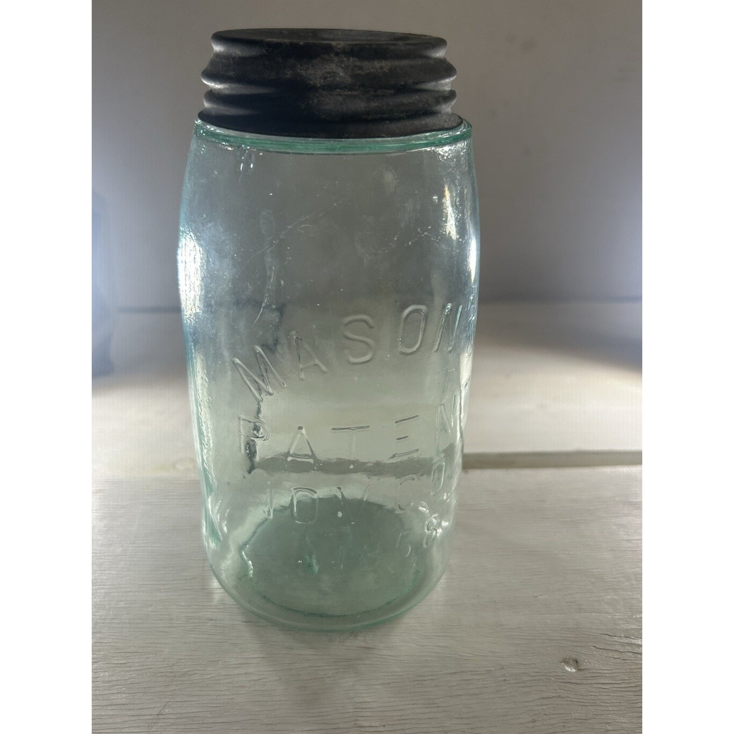 Antique 1858 Mason jar zinc lid close-up — original period closure with age patina