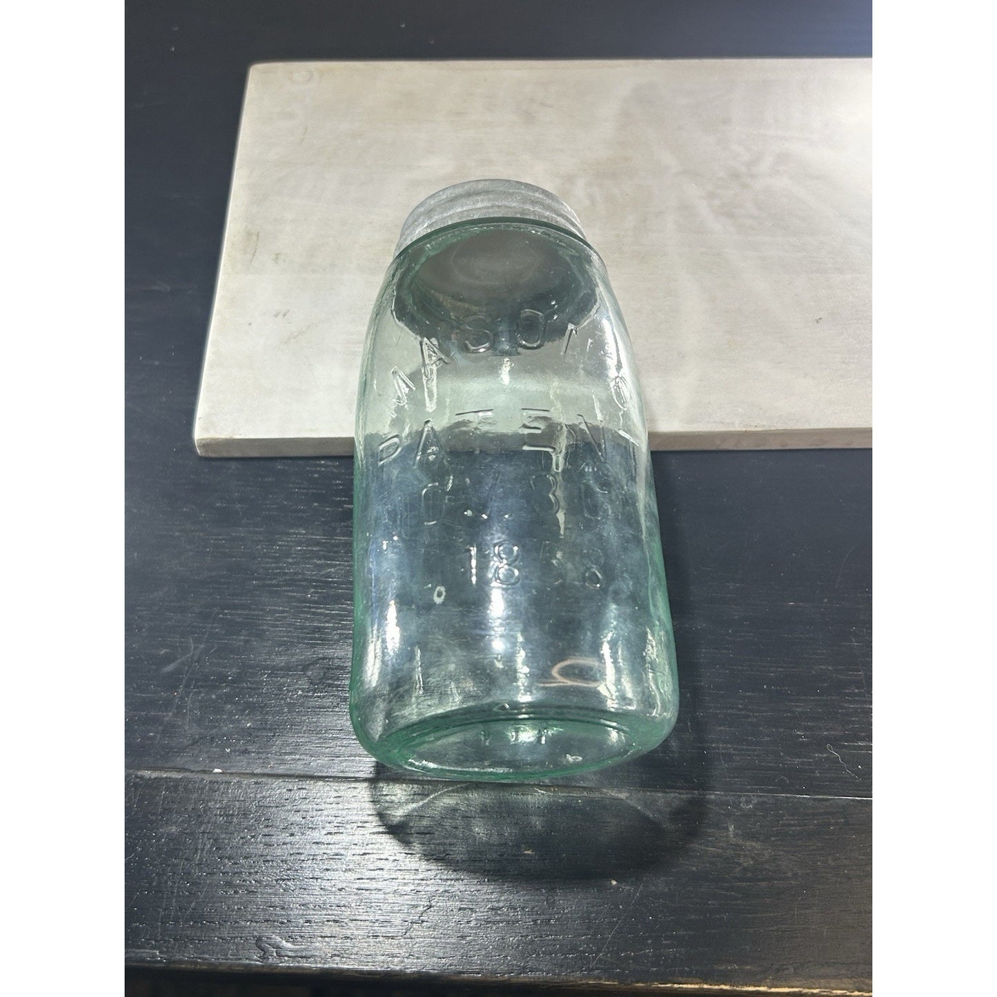 Antique Mason 1858 jar natural light through aqua blue glass showing bubble distribution