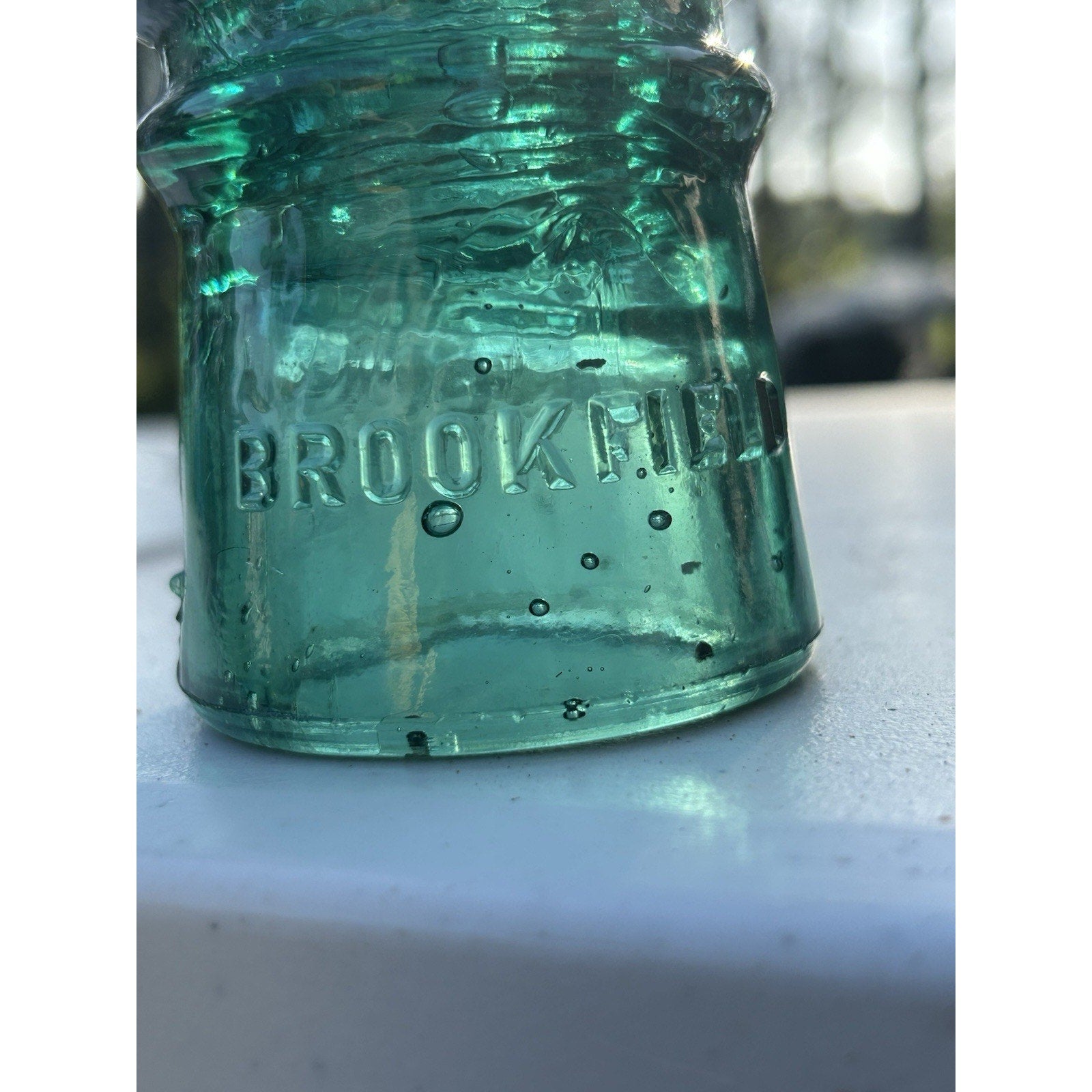 Brookfield dark emerald green glass insulator side view bubbles
