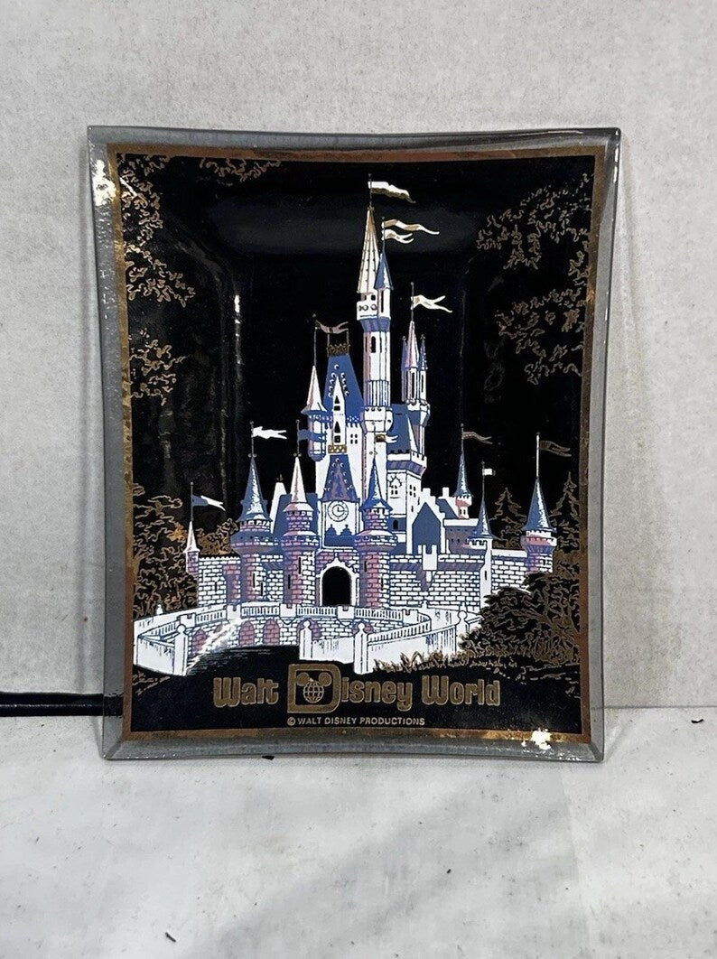 Front view of black Walt Disney World trinket dish with colorful Cinderella Castle and gold border.