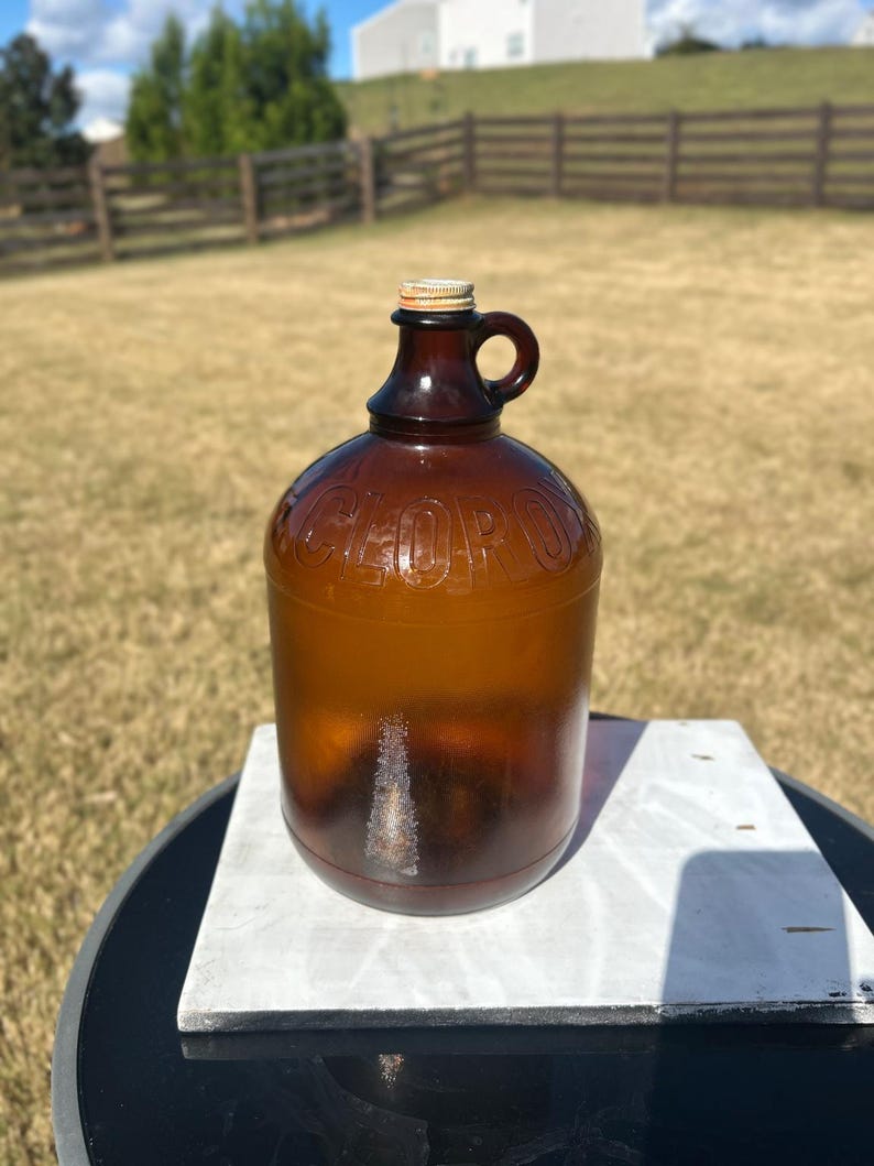 Full outdoor view of the amber jug showing its rounded shoulder and dark lower glass.