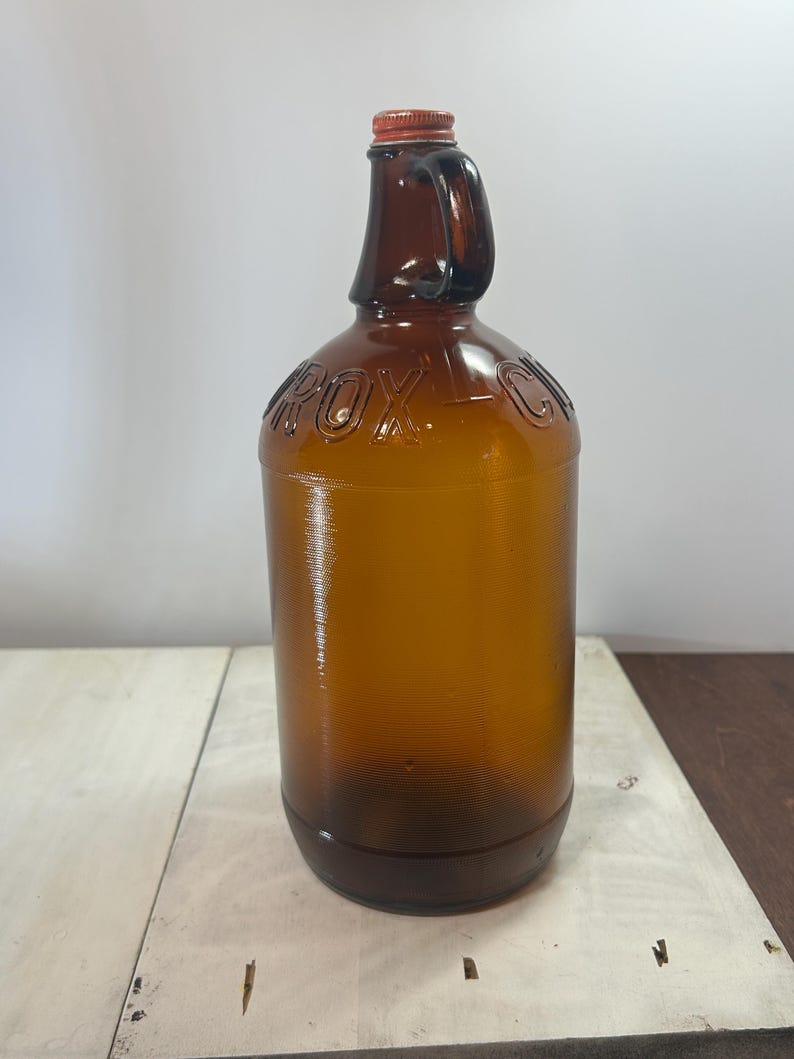 Full indoor view of the smaller amber jug against a light background.