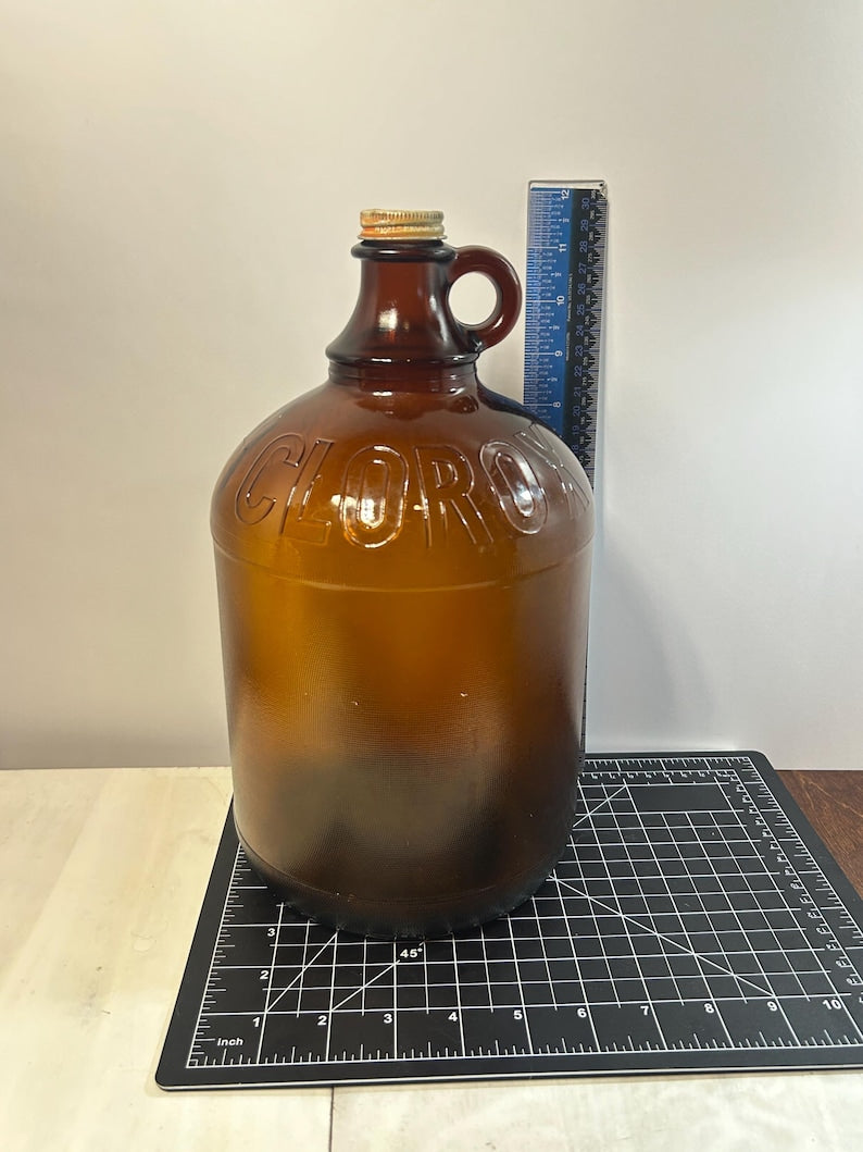 Large jug beside a vertical ruler on a gridded measurement mat.