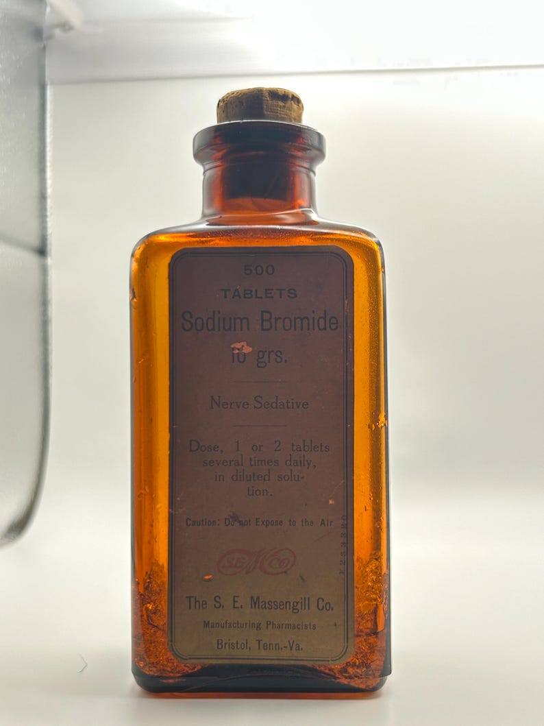 May include: An amber glass bottle with a cork stopper. The label reads "500 Tablets Sodium Bromide 10 grs. Nerve Sedative." The bottle is from The S. E. Massengill Co., Manufacturing Pharmacists, Bristol, Tenn.-Va.