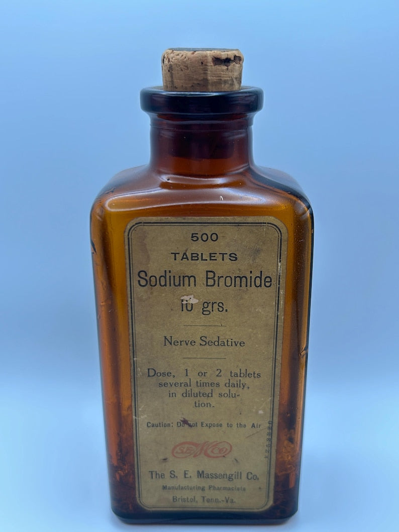 May include: An antique amber glass bottle with a cork stopper. The label reads "500 TABLETS Sodium Bromide 10 grs. Nerve Sedative." The bottle is from The S. E. Massengill Co., Bristol, Tenn.-Va. The label also includes dosage instructions.