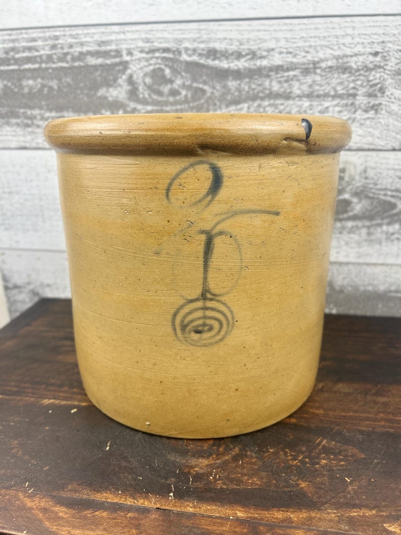 Angled front view showing the rolled rim, ochre glaze, and cobalt painted design.