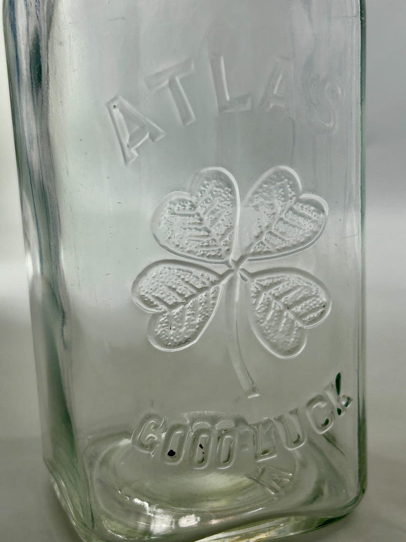 Close-up of the Atlas name, four-leaf clover, and Good Luck embossing.