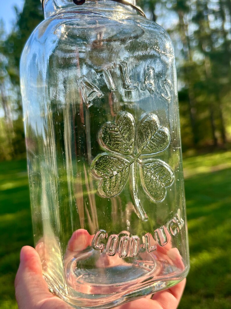Sunlit close-up of the embossed clover held toward the camera.