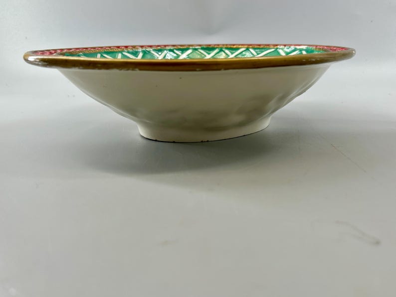 Side profile showing the shallow oval bowl, white ceramic exterior, and patterned rim.